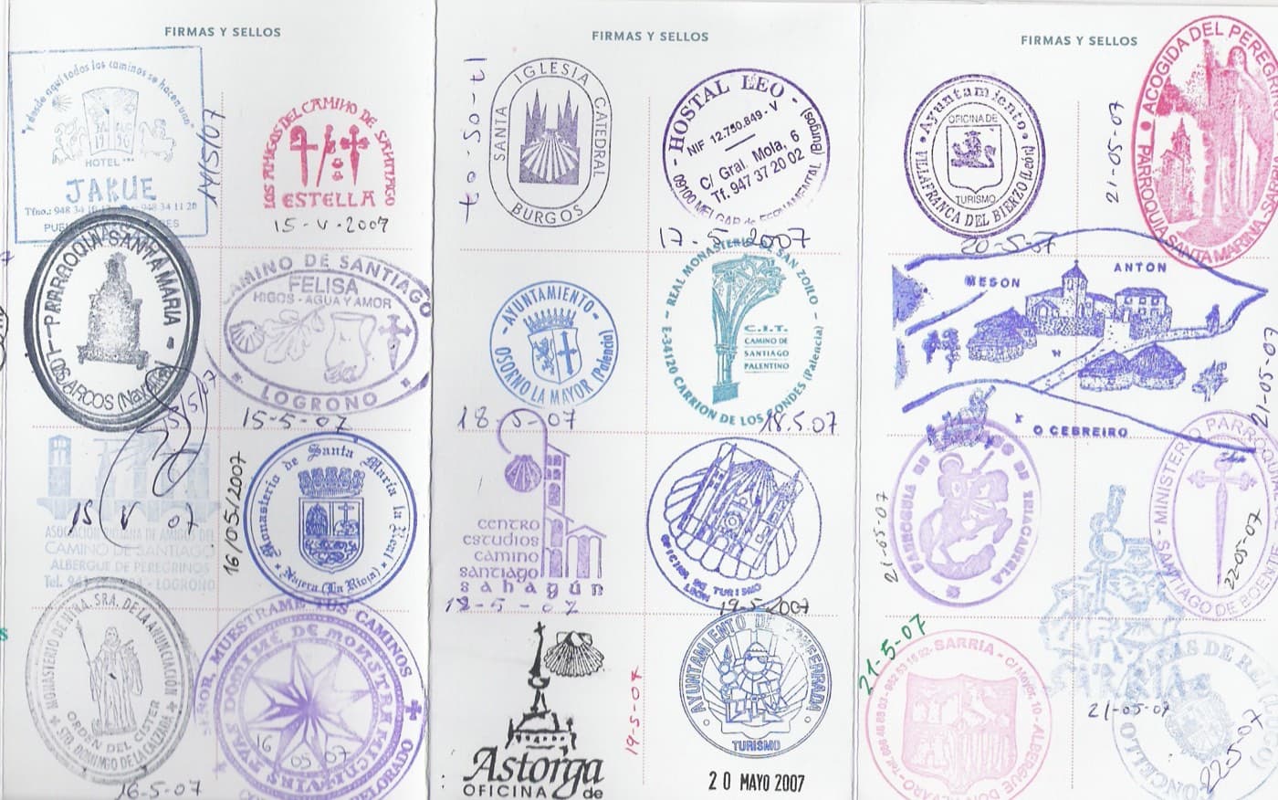 A pilgrim's credencial opened flat, covered in dozens of dated ink stamps from places along the route.